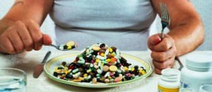 Overweight man eating plate full of pills