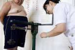 DOCU_GRUPO UNA ENFERMERA ANOTA EL PESO DE UN NIÑO OBESO